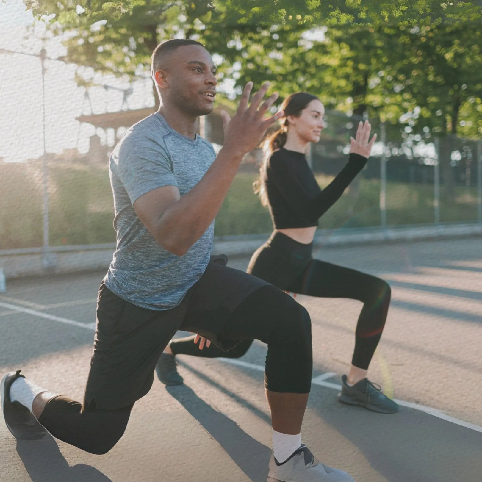 Zwei Personen in sportlicher Haltung auf einem Sportplatz für die Kategorie Energie